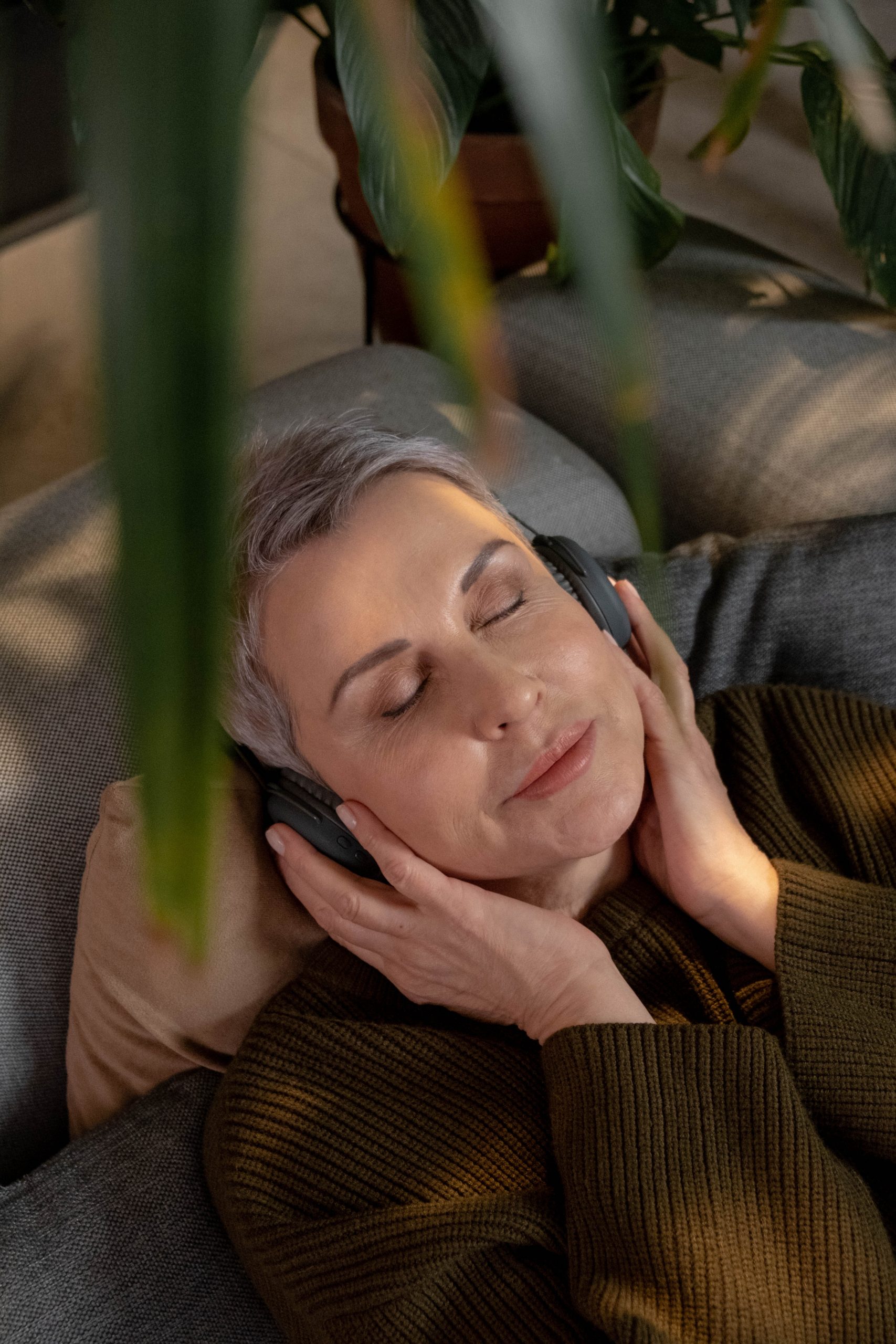 Une personne détendue et les yeux fermés, écoutant un hypnothérapeute avec un casque audio, symbolisant l'écoute d'une séance d'hypnose pour arrêter de fumer.